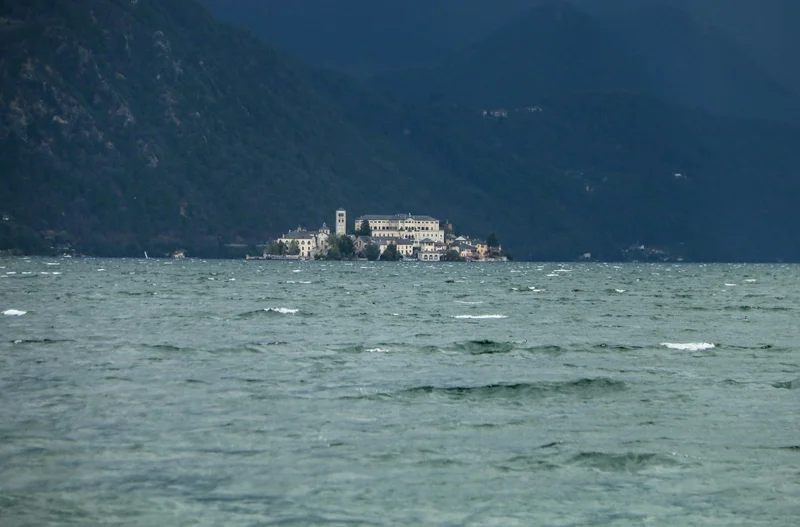 A body of water with San Giulio island in the distance on Lake Orta