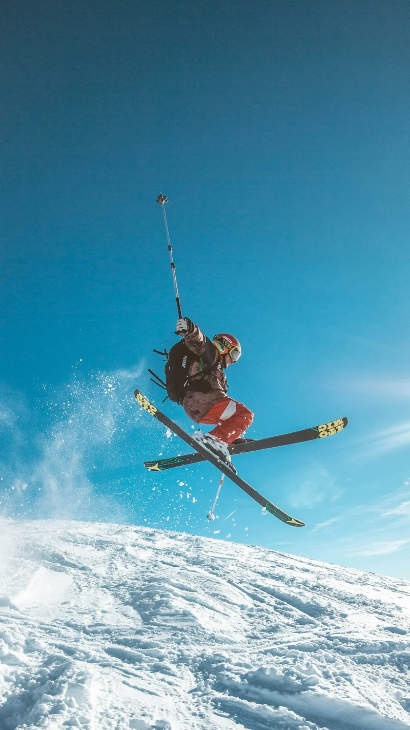 Skier carving through powder snow on alpine terrain